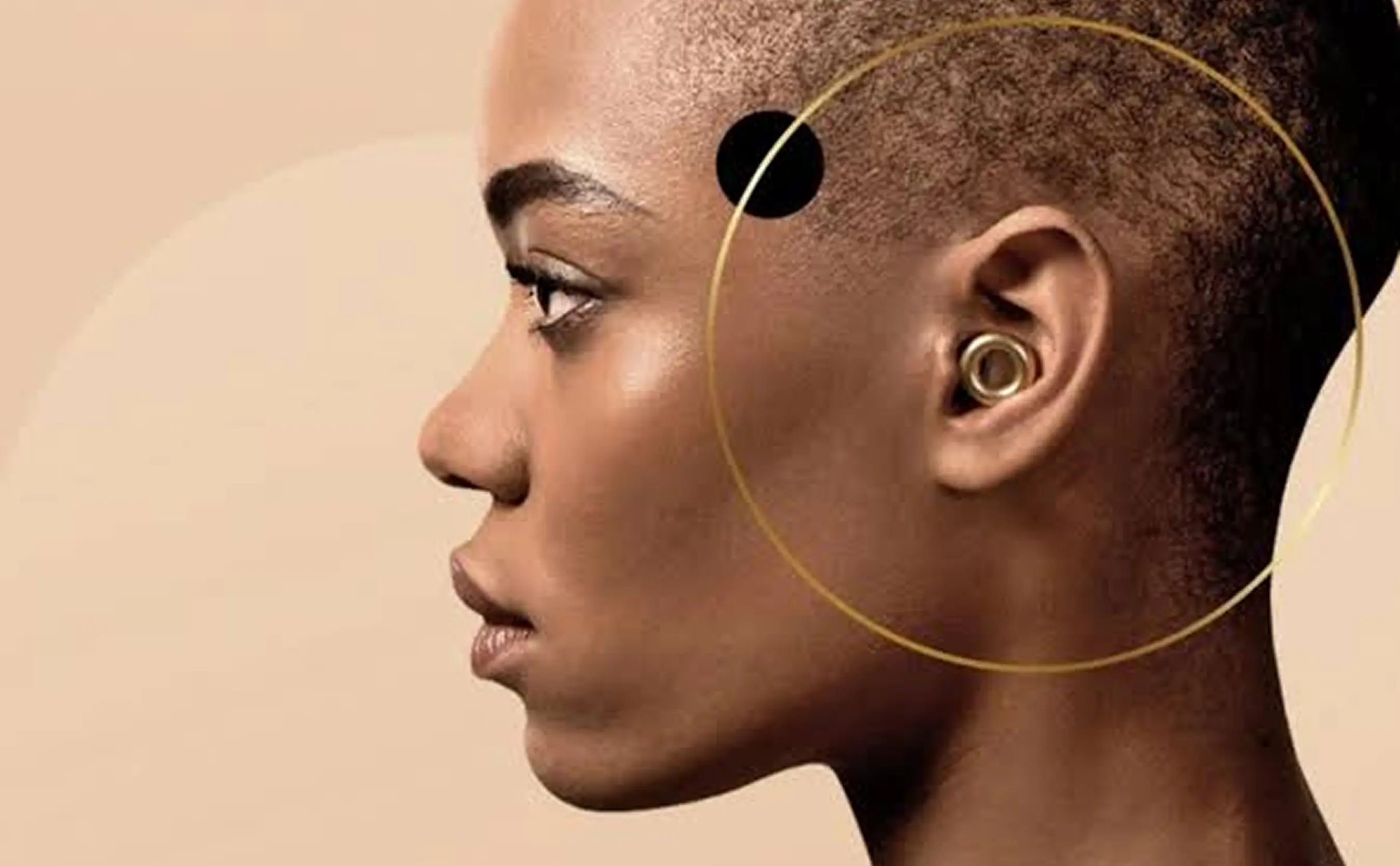 Profilansicht einer Person mit kurzem Haar, die einen Ohrstecker trägt. Ein goldener Kreis ist um das Ohr gezeichnet.