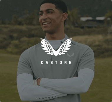 Persona sonriente con una camiseta deportiva gris de Castore y con el logotipo de Castore y texto superpuesto