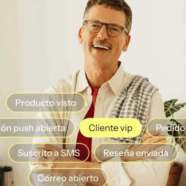 Hombre sonriendo con gafas y camisa clara, rodeado de etiquetas con texto como "Producto visto" y "Cliente vip".