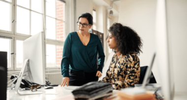 Two people looking at computer in office