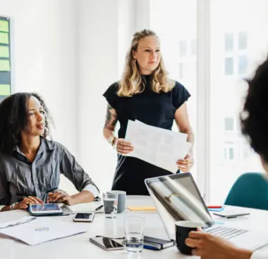 group of women working and talking at a desk