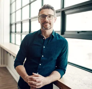 man in a blue shirt smiling at the camera