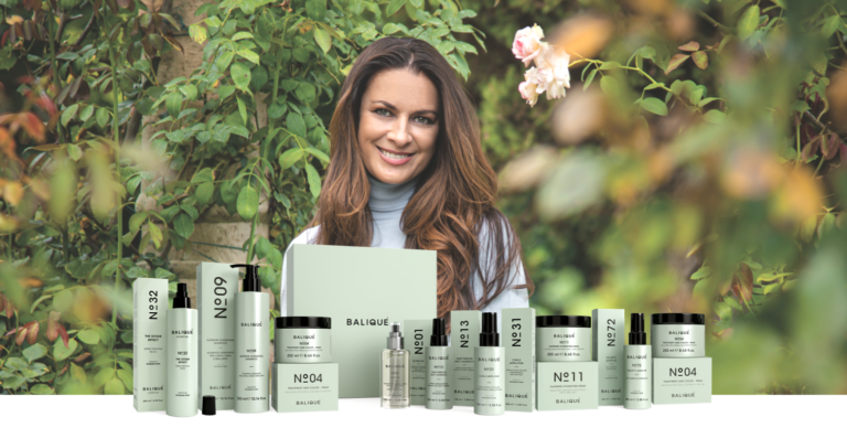 Balique founder Rossana Dian stands in front of a range of Balique hair care products