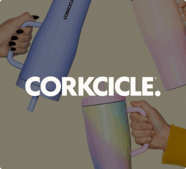 Hands holding colorful Corkcicle tumblers with the Corkcicle logo in the center.