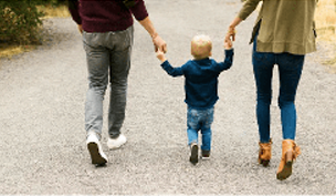 A couple with a child in the middle holding hands