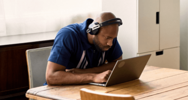 Person working at a desk with headset and laptop