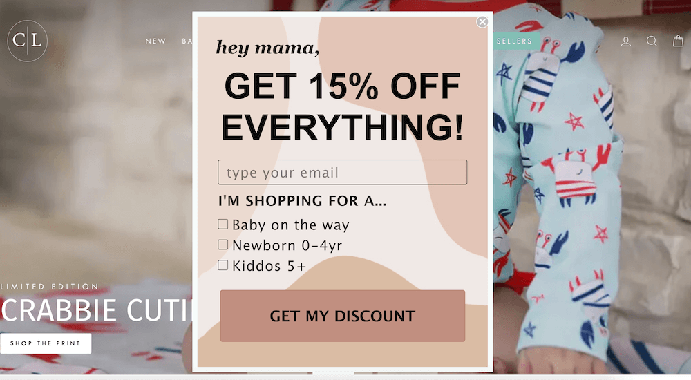 Image shows a pop-up form from Caden Lane, offering 15% off in exchange for the visitor’s email address and encouraging them to identify whether they’re shopping for a baby on the way, newborn 0-4 years old, or kids above the age of 5.