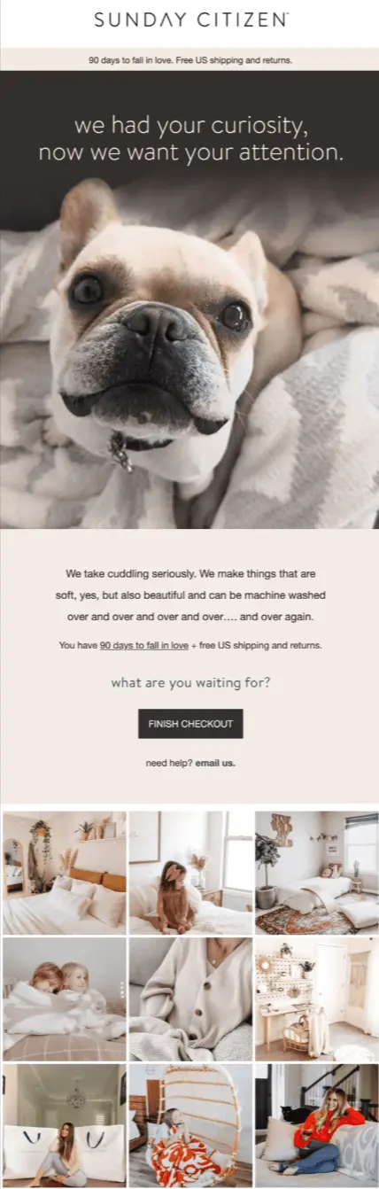 Image shows an abandoned cart email from home goods brand Sunday Citizen. Beneath the brand’s logo is a close-up image of a french bulldog, with the headline, “we had your curiosity, now we want your attention.” The email copy reads, “We take cuddling seriously. We make things that are soft, yes, but also beautiful and can be machine washed over and over and over and over…and over again. What are you waiting for?” Underneath the black CTA button, which reads “FINISH CHECKOUT,” is a line that says, “need help? Email us” and then a 9-photo grid of recent photos from the brand’s social media.