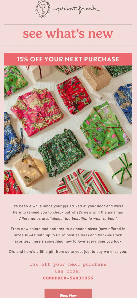 Image shows a pink-themed winback email from sleepwear brand Printfresh, which kicks off with the headline “see what’s new” followed by a banner promoting “15% off your next purchase.” Beneath a large, colorful product shot of various PJ tops and bottoms folded up neatly on a gift-wrapping table, the email copy reads, “It’s been a while since your pjs arrived at your door and we’re here to remind you to check out what’s new with the pajamas Allure notes are ‘almost too beautiful to wear to bed.’” At the bottom of the email is a clear, direct CTA button: “Shop new.”