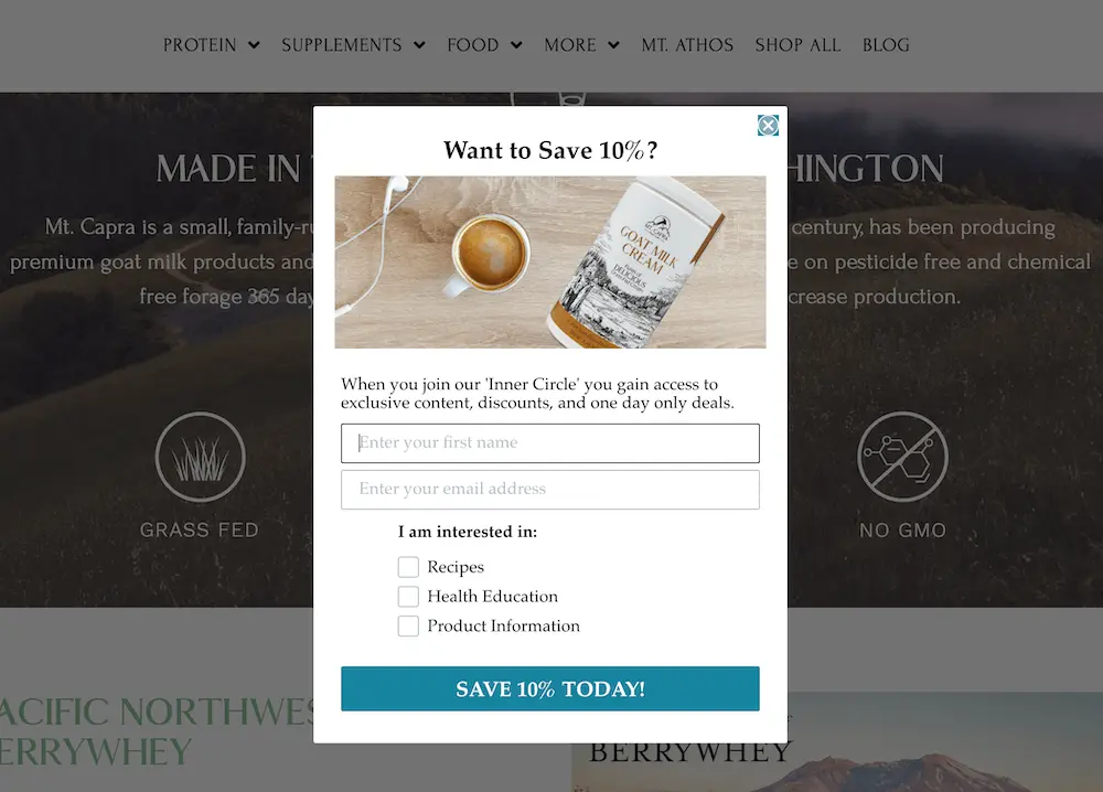 Image shows a sign-up form on the Mt. Capra website, with the headline “Want to save 10%?” above a photo of a package of their goat milk cream next to a cup of coffee on a wooden background. The sign-up form copy reads, “When you join our inner circle you gain access to exclusive content, discounts, and one day only deals.” Beneath two form fields where the shopper is instructed to enter their first name and their email address, they also have the option to check a box under the subheading “I am interested in”: recipes, health education, and/or product information. The CTA button at the bottom reads, “save 10% today.”