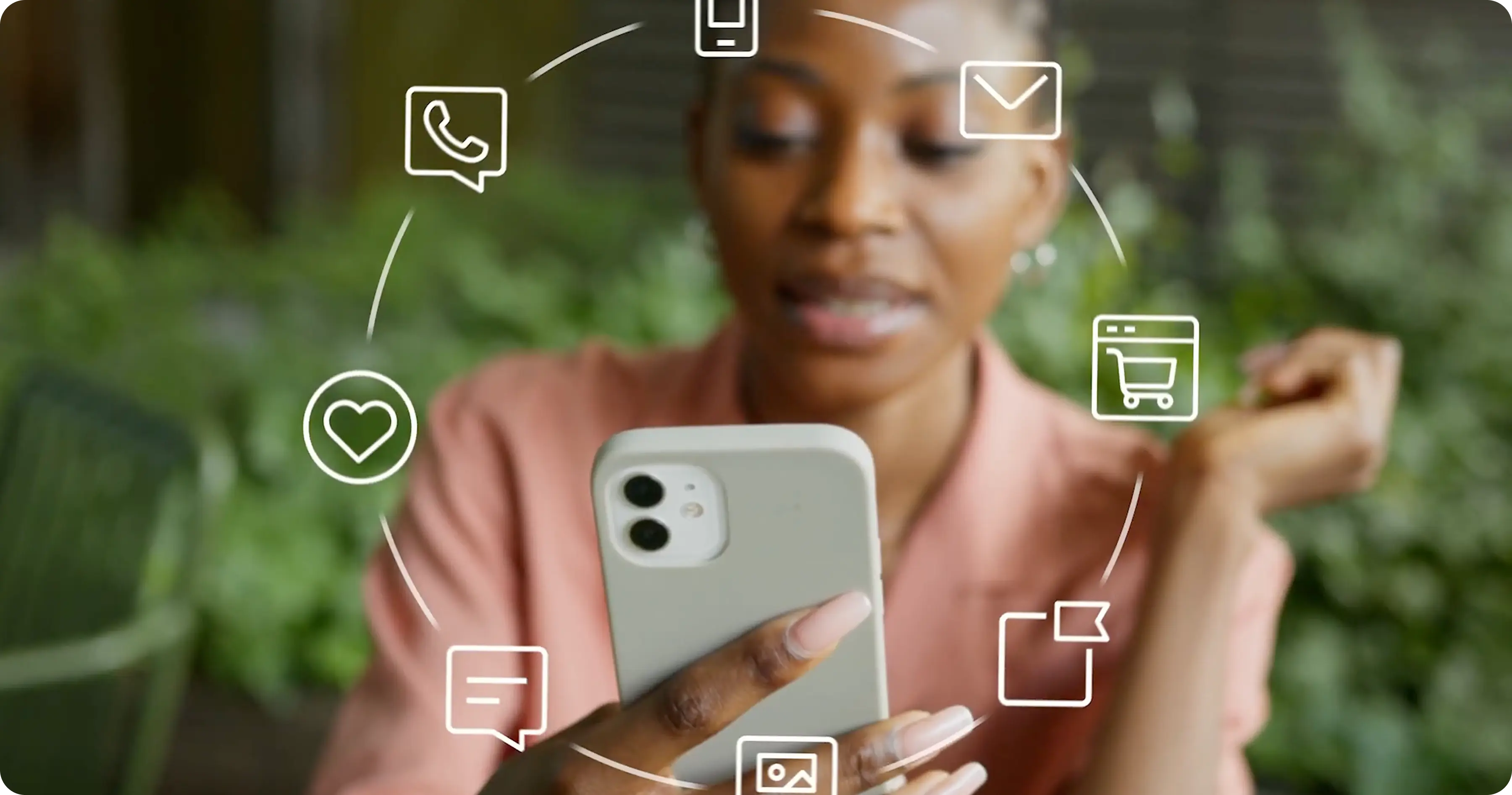 A woman looks at her phone, framed by a ring of icons representing various channels: email, SMS, WhatsApp, and more.