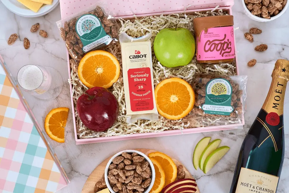 Gift basket with cheese, apples, orange slices, almonds, and chocolate. Includes a Moët & Chandon champagne bottle.